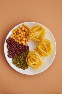 Overhead shot of tagliatelle pasta, chickpeas, kidney beans, and green lentils on a plate.